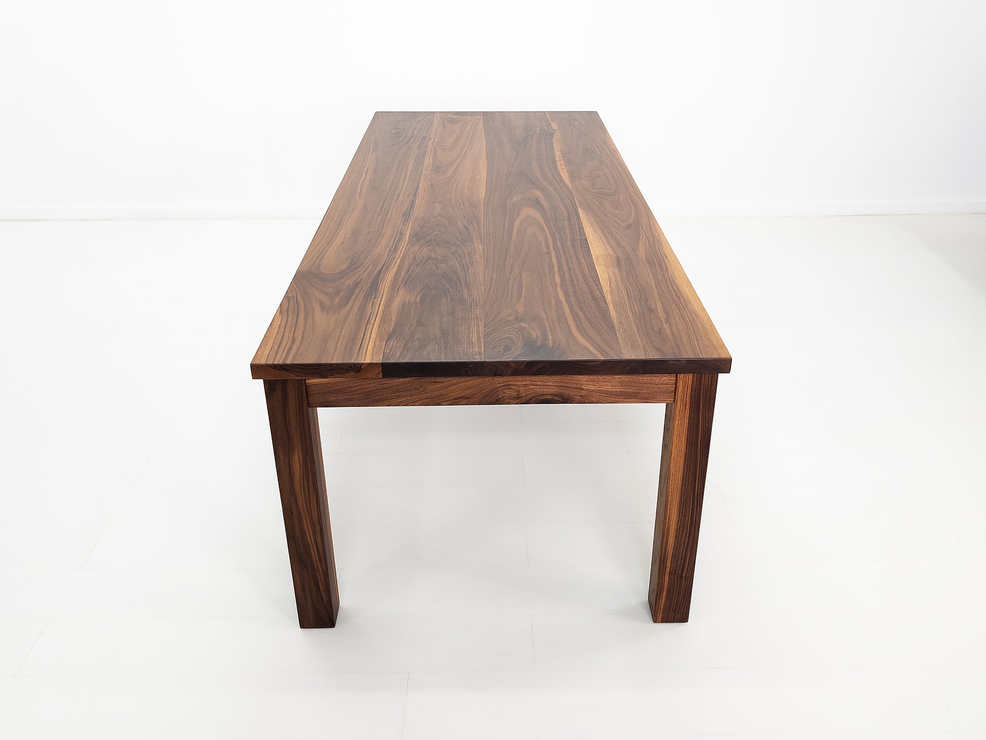 JONA dining table in oiled walnut with square legs.