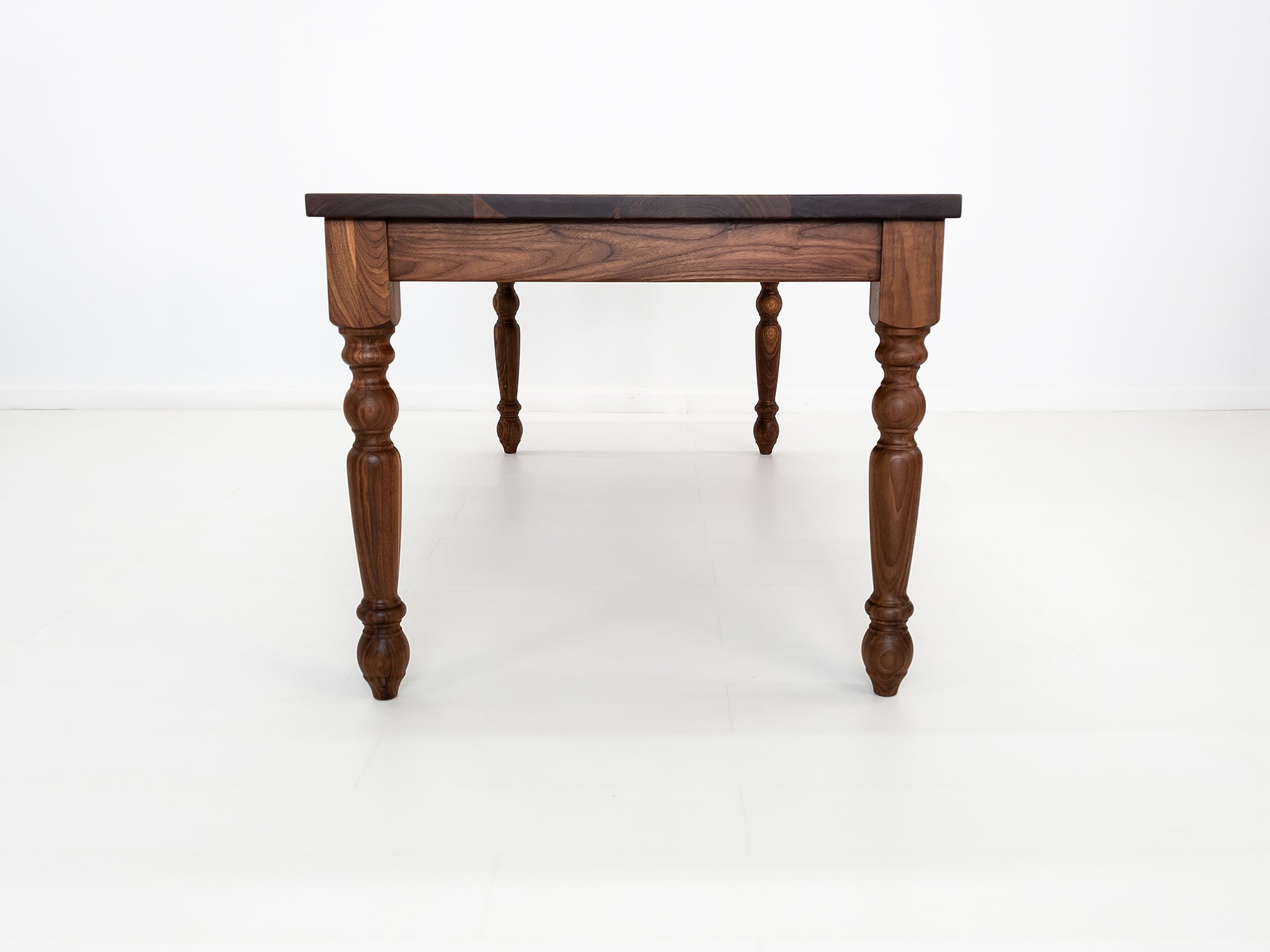 Handcrafted walnut dining table with classic turned legs.