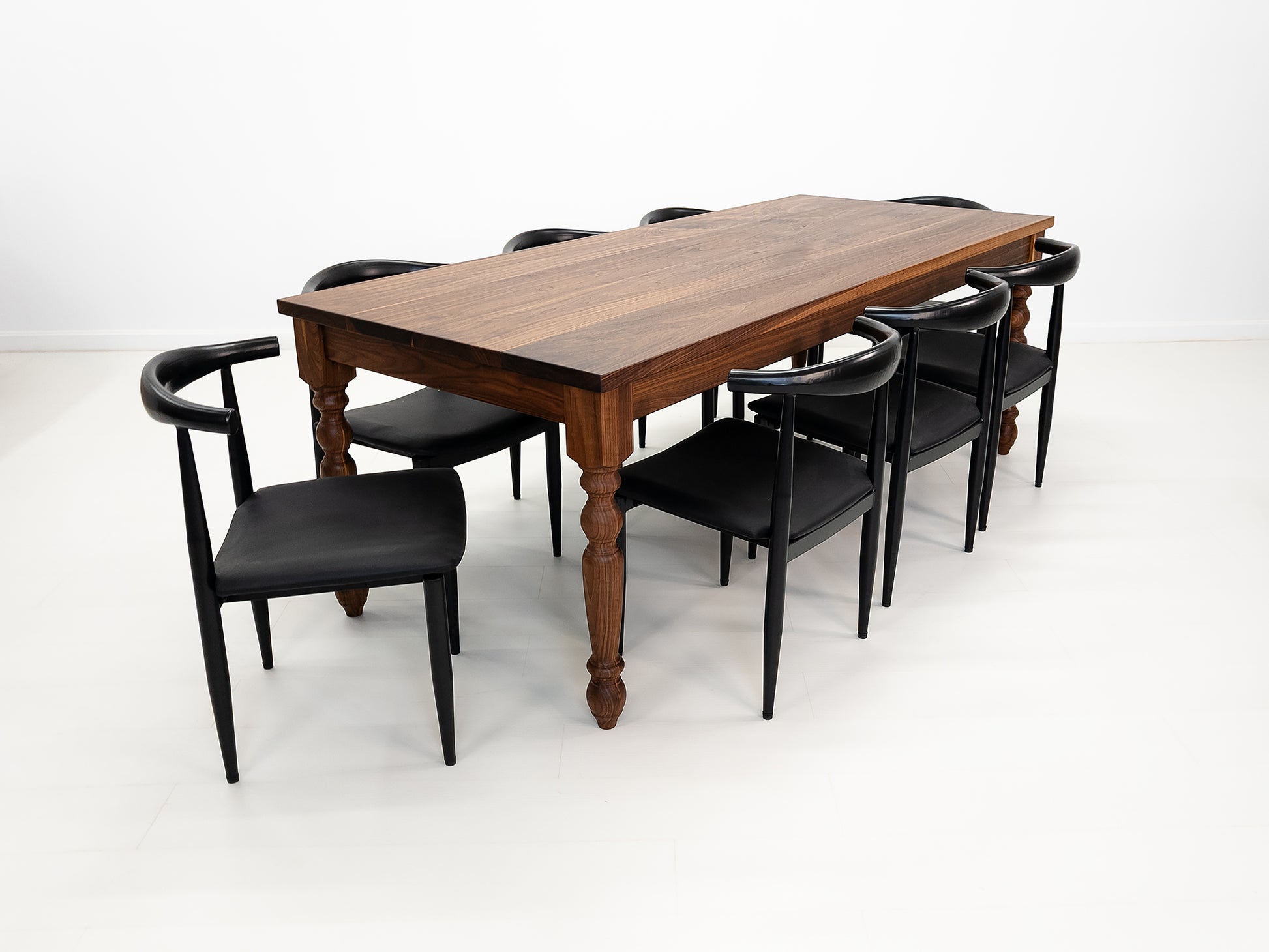 Handcrafted walnut dining table with classic turned legs.