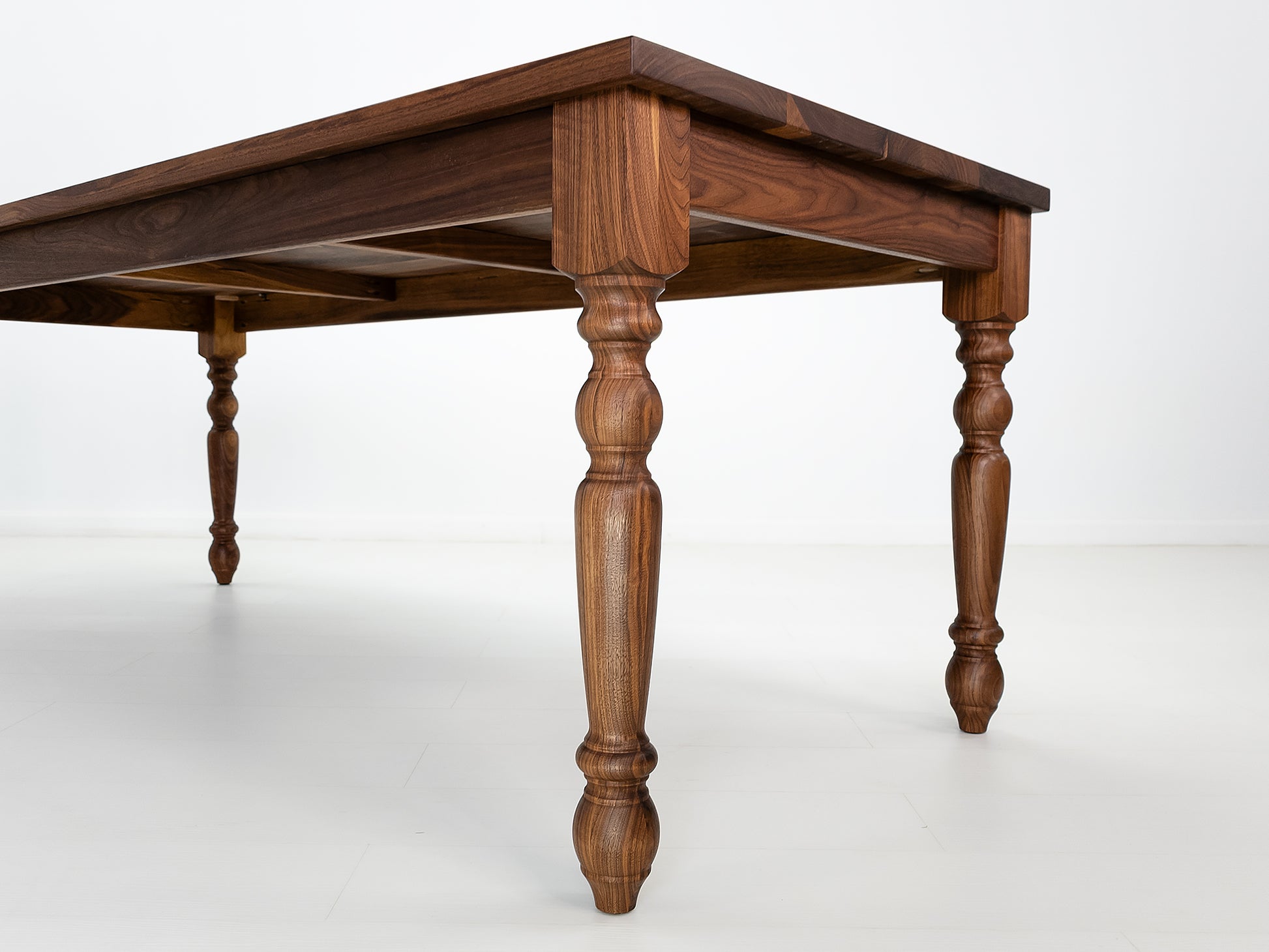 Close up of a TESS dining table in oiled walnut.