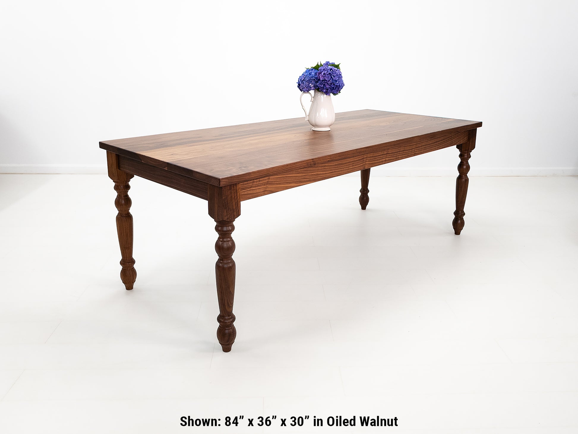 Handcrafted walnut dining table with classic turned legs.