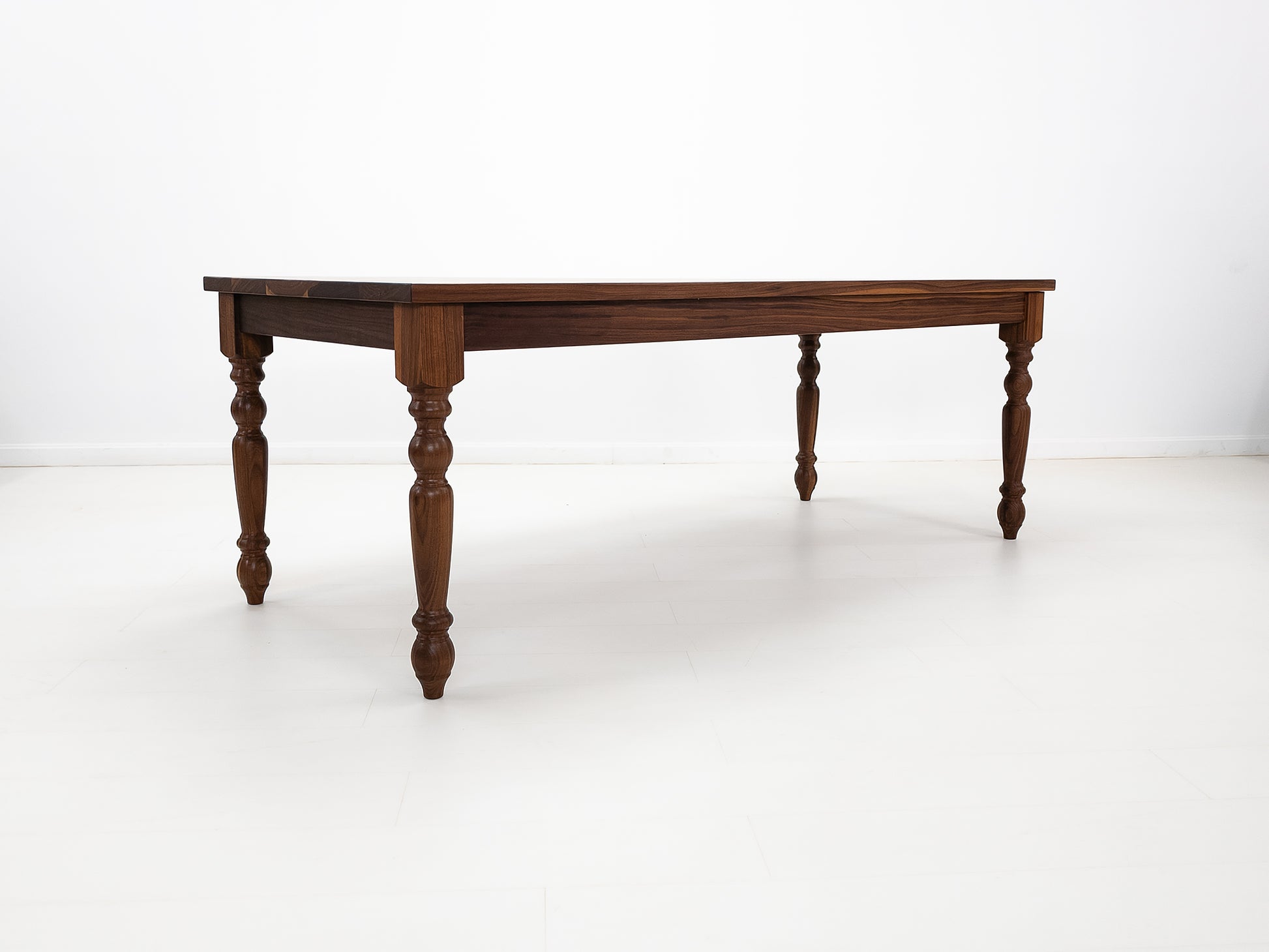 Handcrafted walnut dining table with classic turned legs.