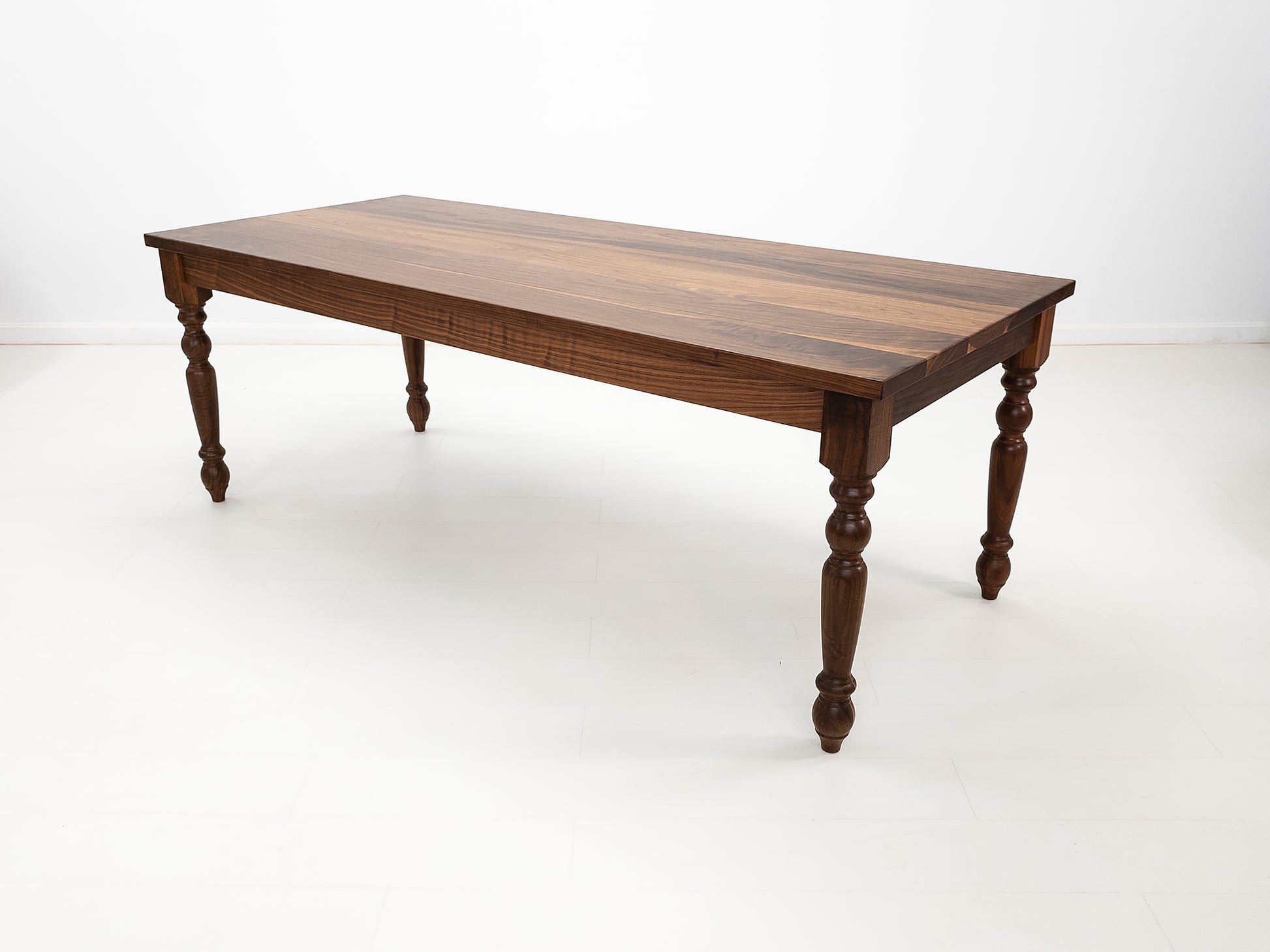 Handcrafted walnut dining table with classic turned legs.