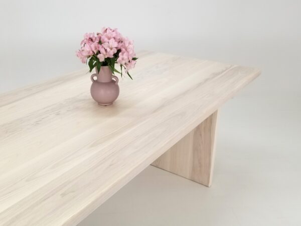 A LILY 1.5 panel dining table with pink flowers in a vase.