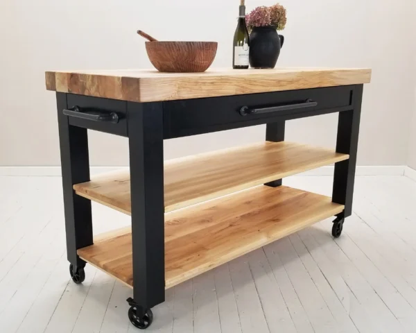 A butcher block cart with wheels and drawers on it