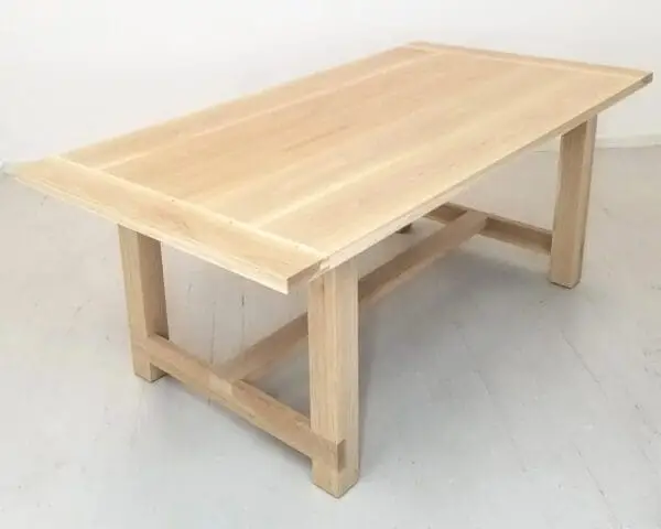 A natural white oak trestle dining table.