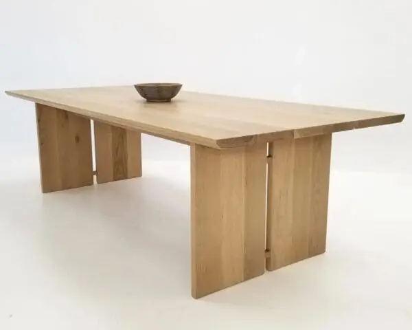 A DIVI Dining Table with Split Panel Legs shown in natural white oak.