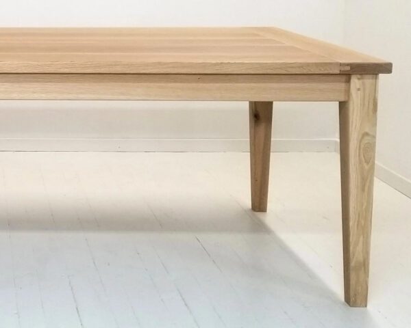A close up of a tapered leg dining table.