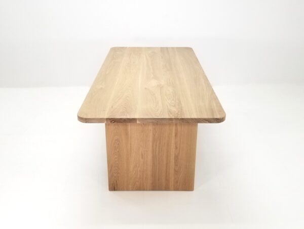 A TIAN dining table with rounded corners with a square base.