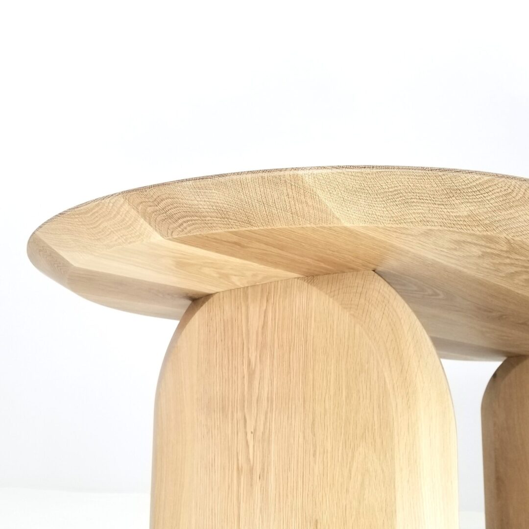 A close up of a white oak oval dining table.