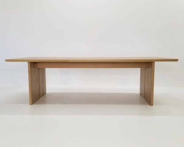 A DIVI Dining Table with Split Panel Legs shown in natural white oak.