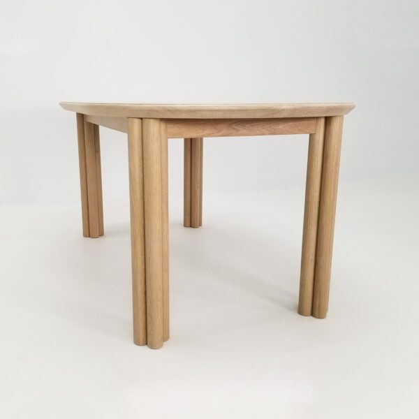 A cylinder leg dining table with four legs.