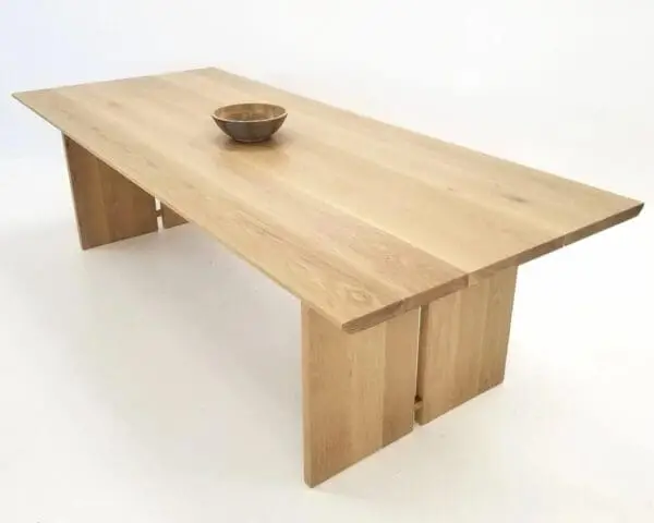 A DIVI Dining Table with Split Panel Legs shown in natural white oak.