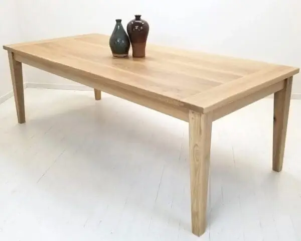 A tapered leg dining table with vases on top.