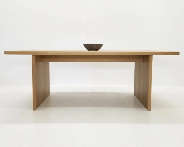 A TIAN Dining Table with Rounded Corners and a bowl on top in front of a white background.