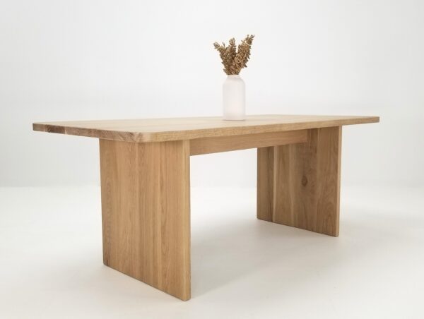 A white oak TIAN Dining Table with Rounded Corners with a vase on top.
