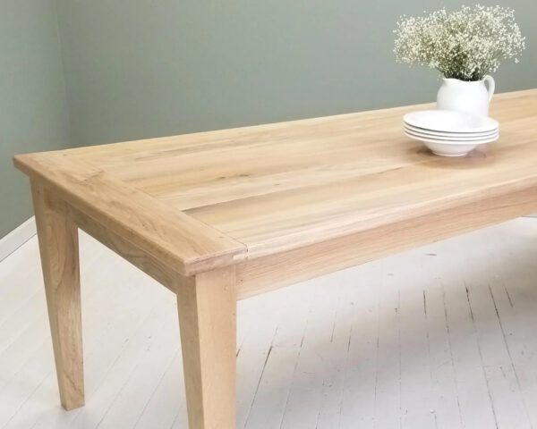 A tapered leg dining table with a plant on top.