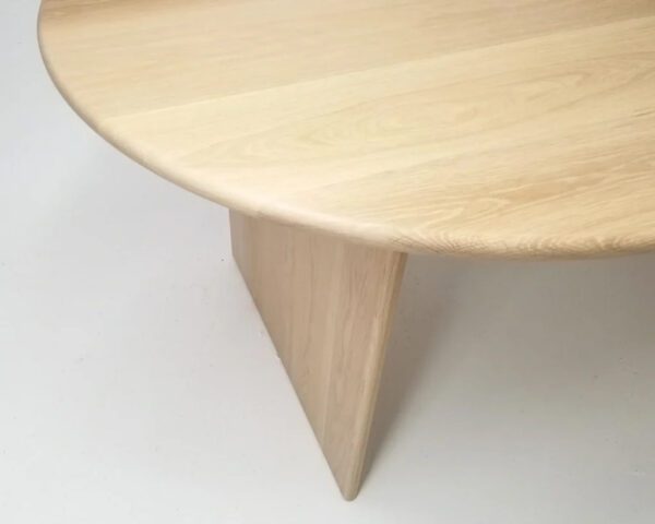 A wooden dining table with a curved top.