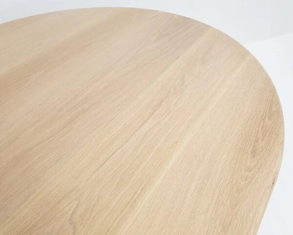 A wooden dining table with a curved top.