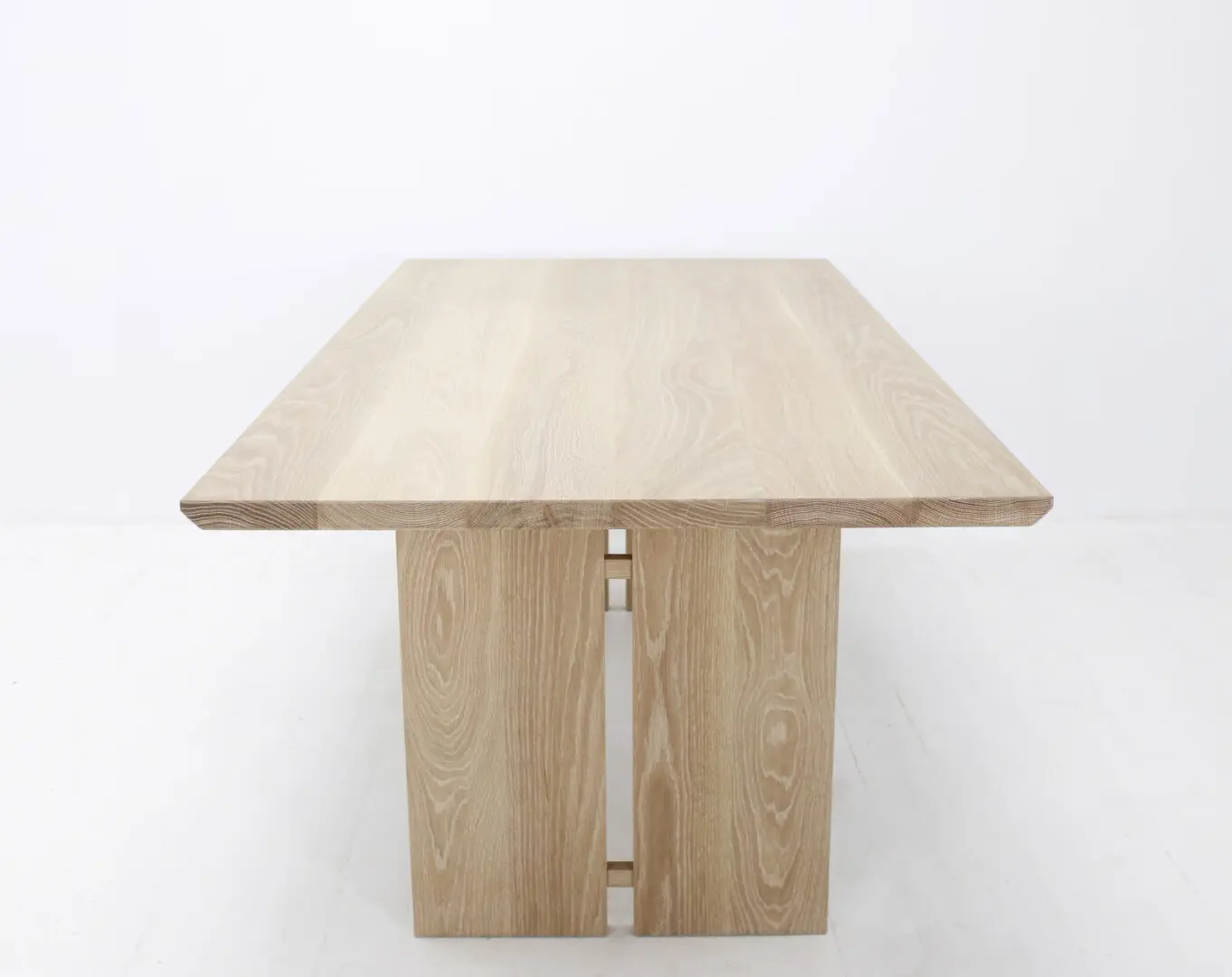 A wooden table with split panel legs.