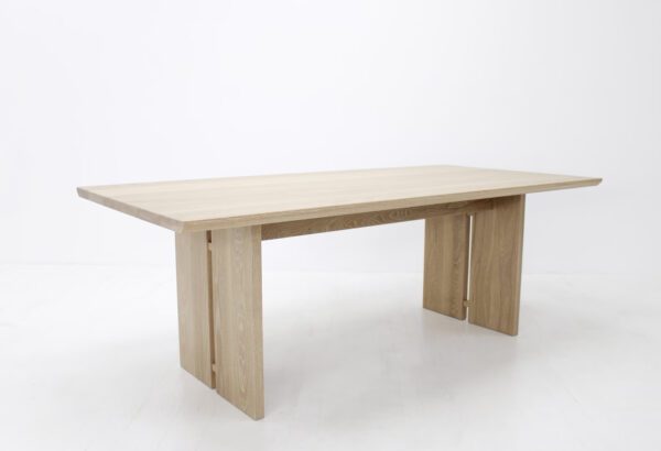 A wooden table with split panel legs.