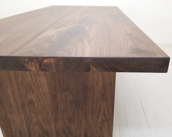A close up of a 2 inch thick solid walnut dining table.