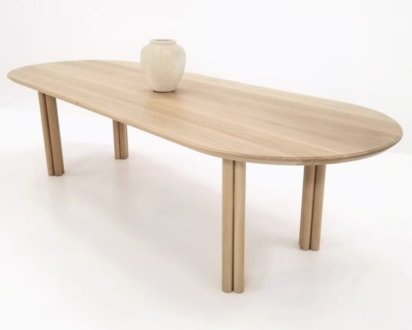 A white oak dining table with a vase on top of it.