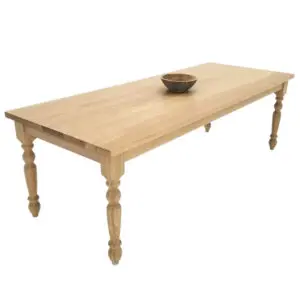 A wooden farmhouse dining table with a bowl on top of it.