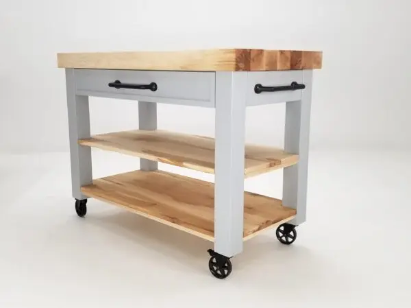 Sentence with product name: The CHEF Custom Maple Butcher Block Cart with wheels and a wooden top.