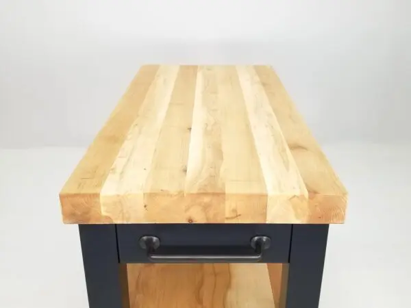A black kitchen table with a wooden top that resembles the CHEF Custom Maple Butcher Block Cart.