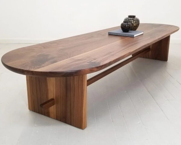 A trestle coffee table with a tea kettle on top.