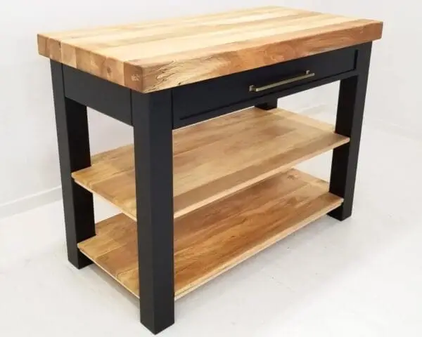 A black butcher block kitchen island with shelves underneath it.