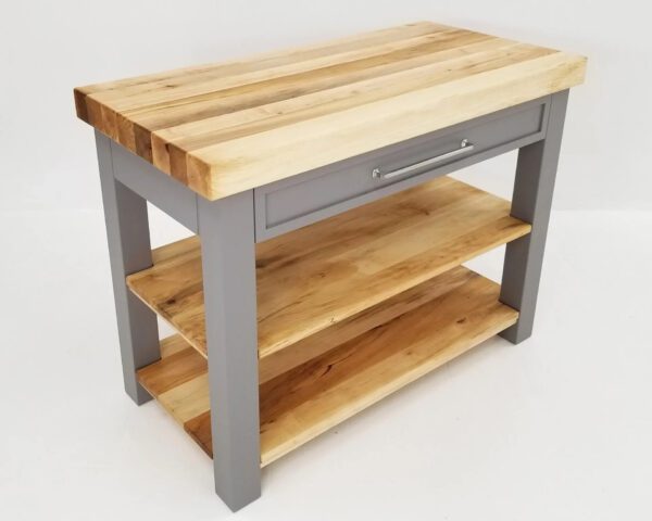 A grey butcher block kitchen island with shelves underneath it.