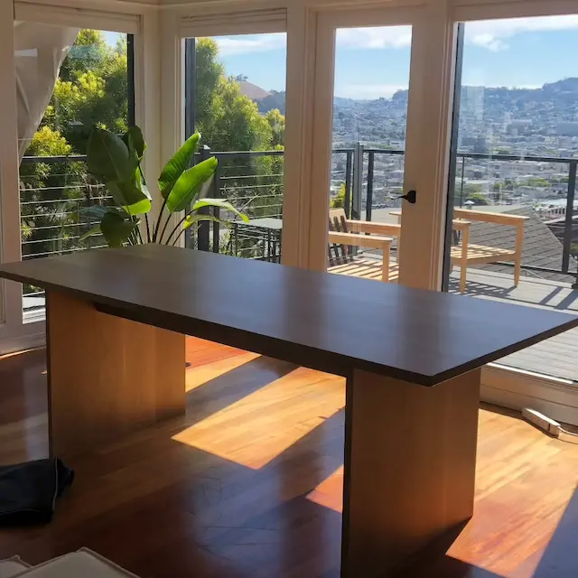 A dining table in a room with client photos and a view of the city.