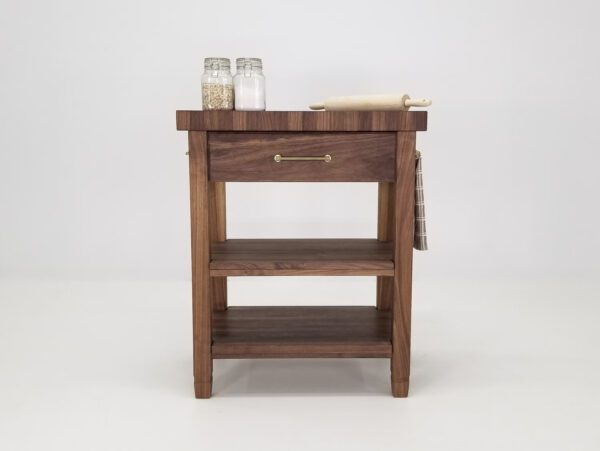 A walnut end-grain butcher block kitchen island with baking items on top.