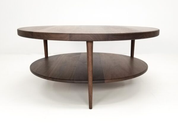 A walnut coffee table with three tapered legs.
