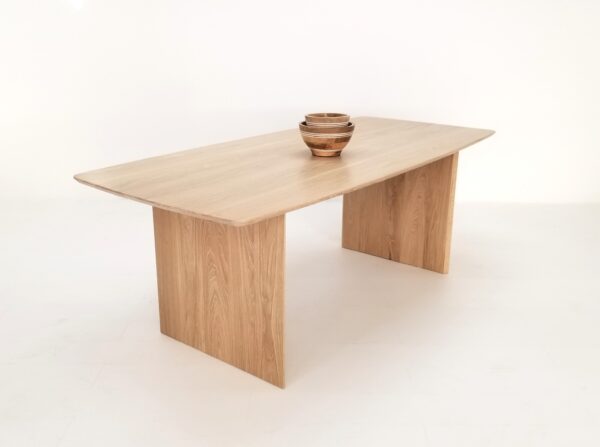 A white oak table with a beveled edge and a bowl on top of it.