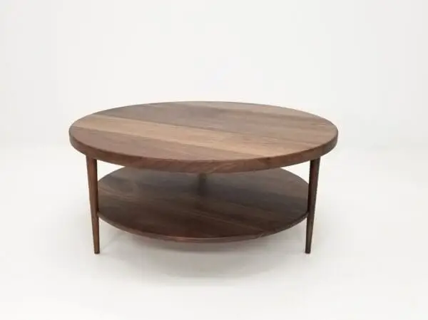 A walnut coffee table with three tapered legs.