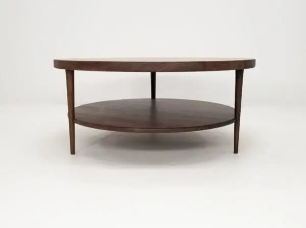 A walnut coffee table with three tapered legs.