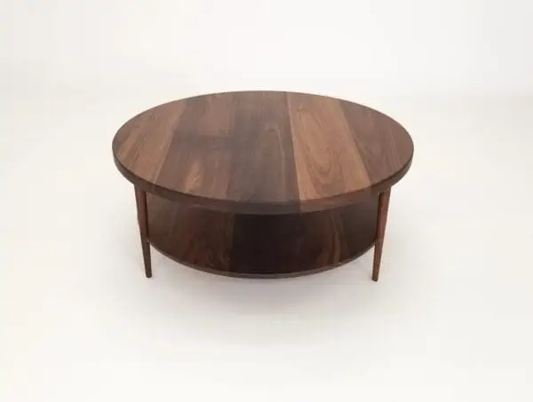 A walnut coffee table with three tapered legs.