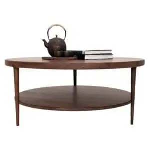 A walnut coffee table with three tapered legs and a tea set on top of it.