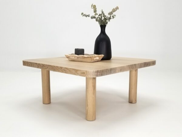 A seawashed, quarter-sawn white oak coffee table with a vase on top.