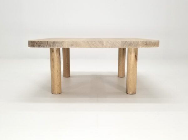 A seawashed, quarter-sawn white oak coffee table with four round legs.
