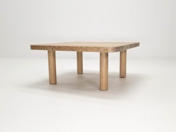 A seawashed, quarter-sawn white oak coffee table with rounded corners and four round legs.