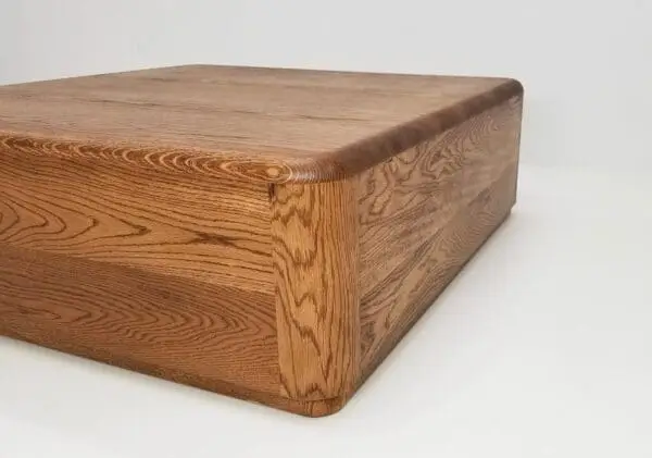 A close up of the corner of a oiled white oak coffee table.