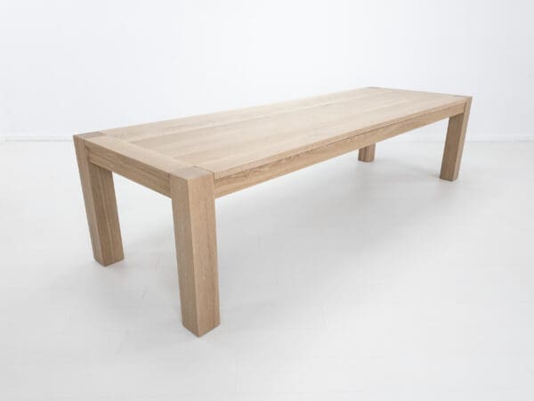 A square leg dining table with a cerused finish.