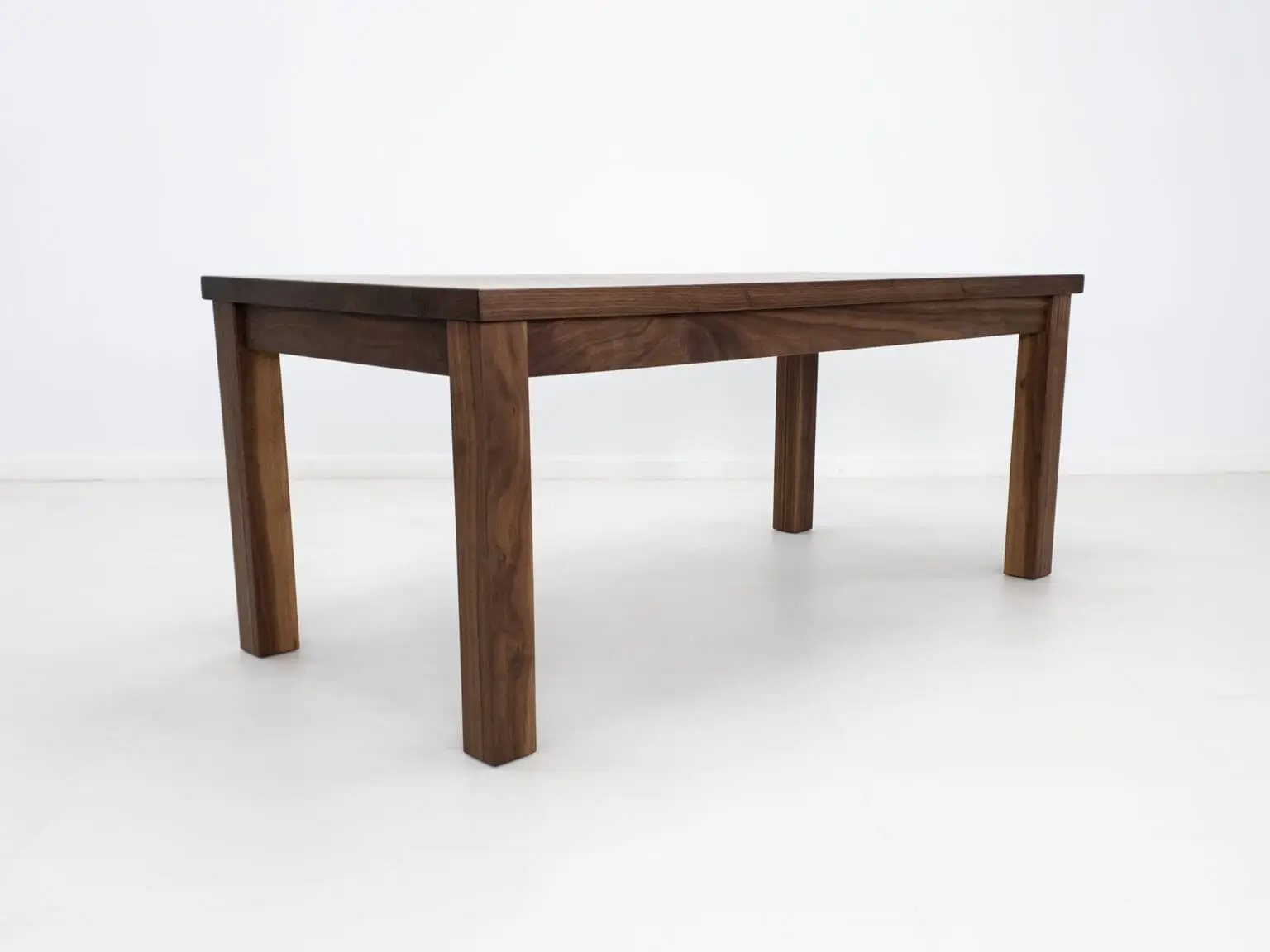 A parsons style walnut dining table