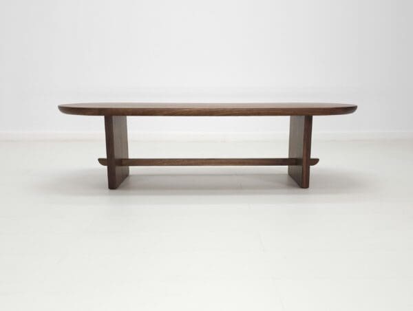 A solid walnut trestle coffee table.