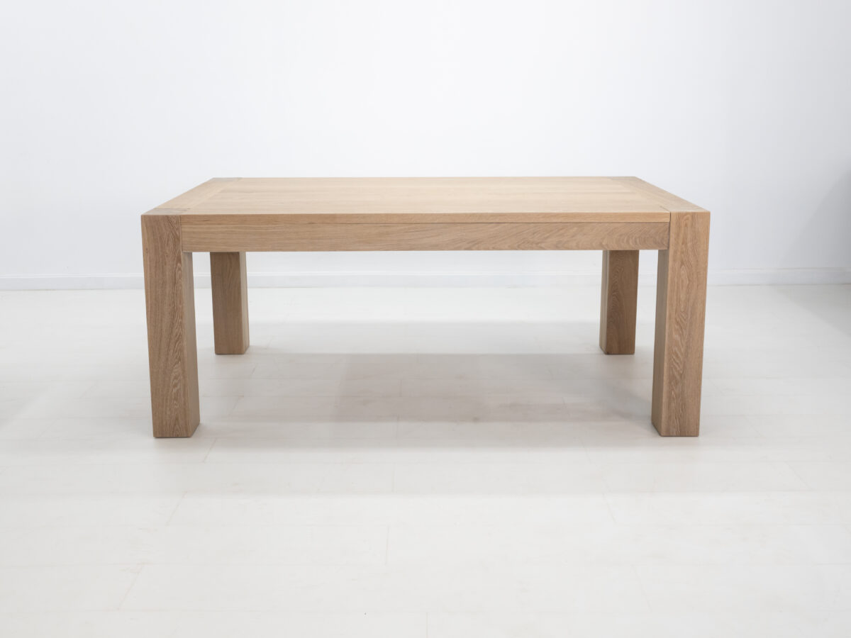 JAQI dining table in seawashed white oak finish featuring a seamless top with breadboard ends