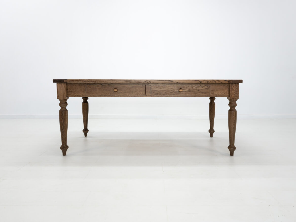 Front view of the ETTA dining table in Antique Harvest showcasing its turned legs and Shaker styled drawers